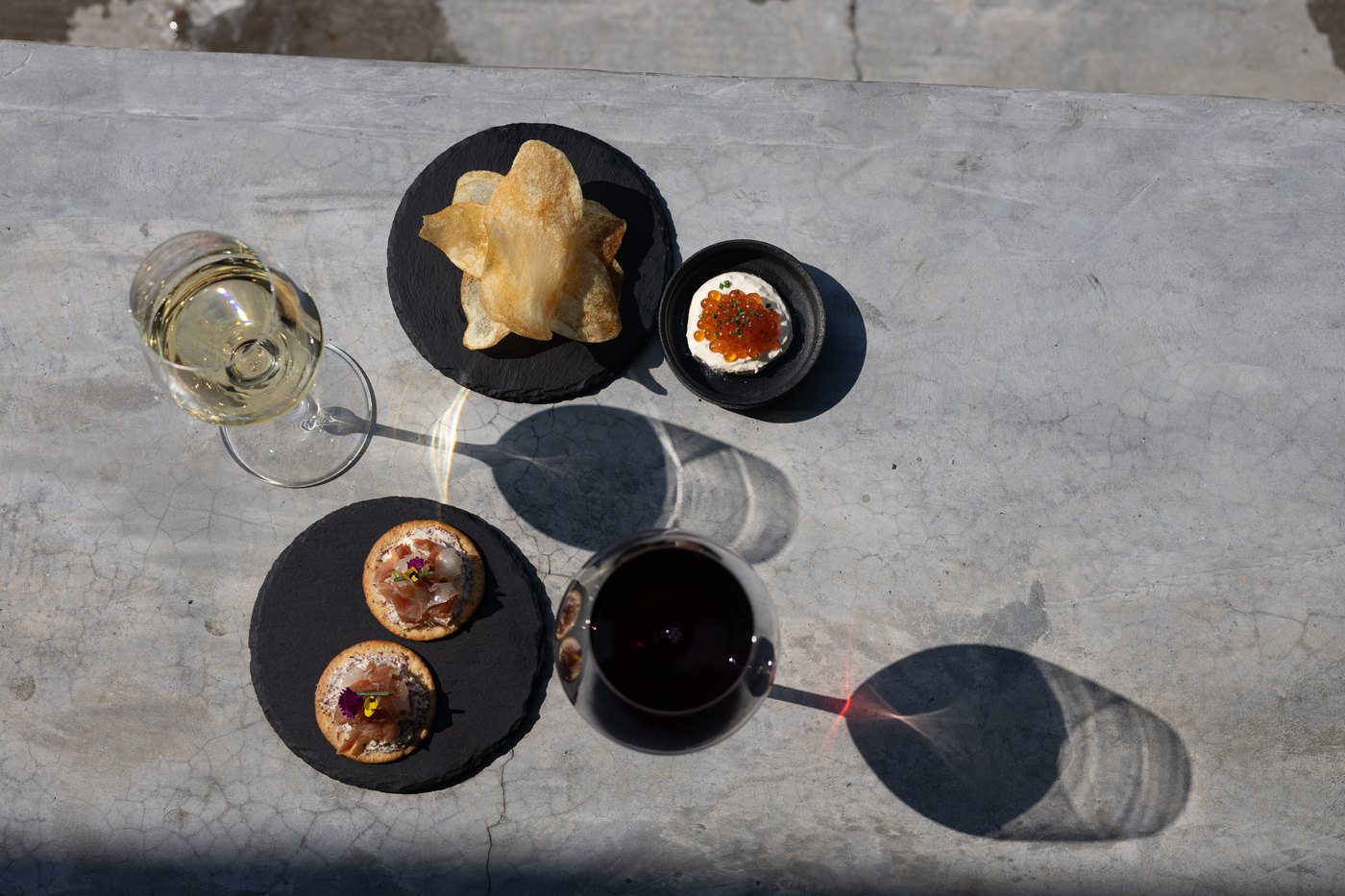 日光下的 MOTD 餐桌，摆放着葡萄酒与小食
